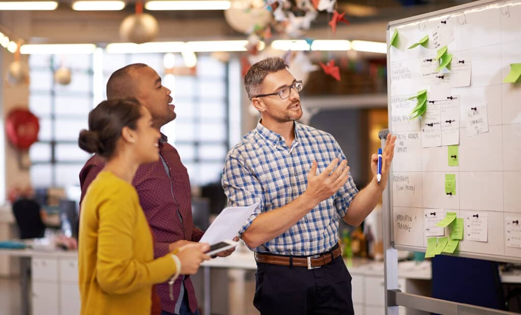 Whiteboard, manager plan and business people with strategy and speaking in a office. Startup, company training and creative writing group with communication and vision with ideas and seo report