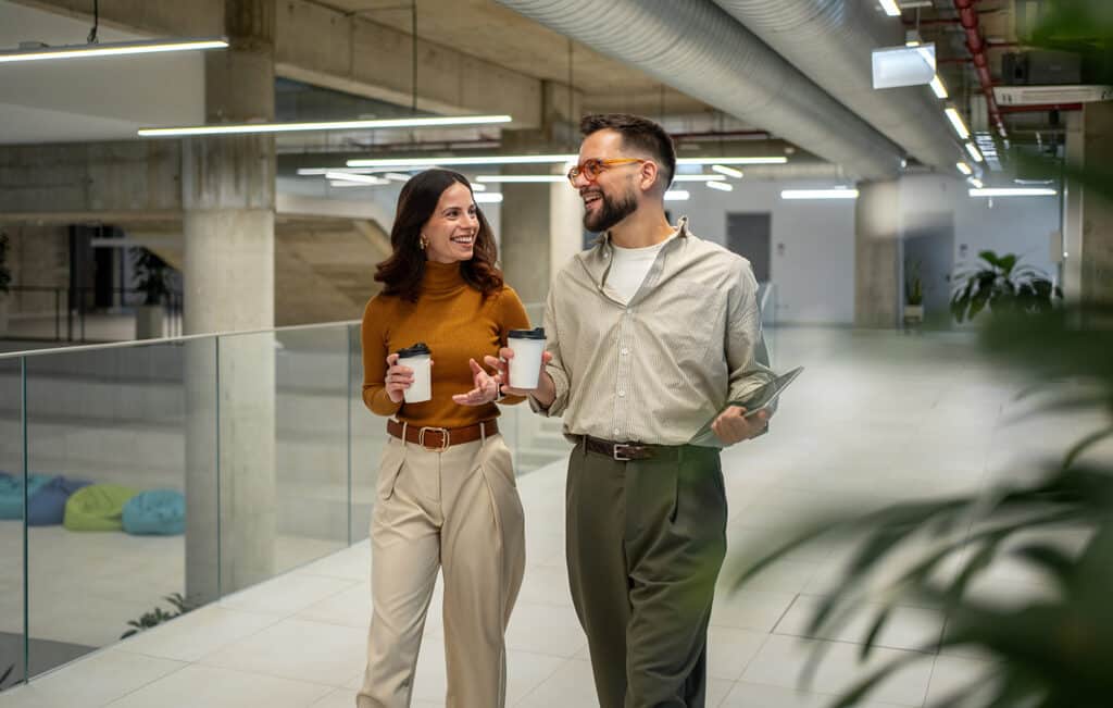 Business colleagues walking, talking, and drinking coffee in off