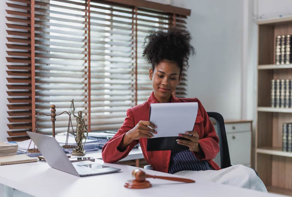 Female lawyer reviewing legal documents at her office desk